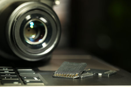 SD memory cards and photo camera on laptop, closeup