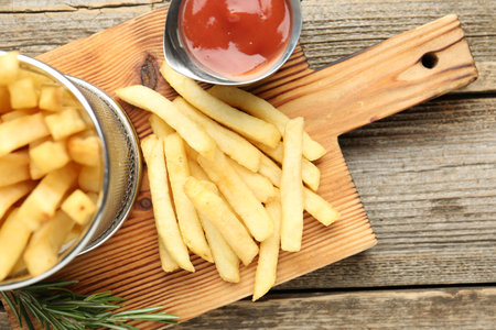 Tasty french fries served with ketchup and rosemary on wooden table, top viewの写真素材