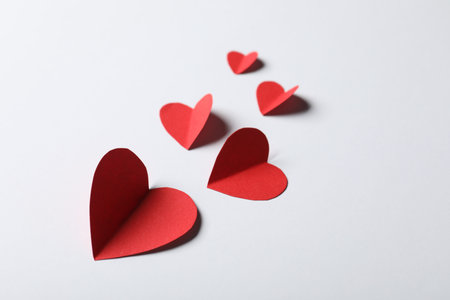 Paper hearts on light grey background, closeup