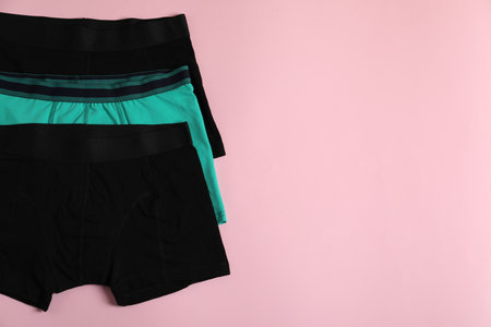 Comfortable men's underwear on pink background, flat lay. Space for textの写真素材
