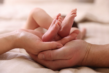 Parents with their little baby on bed indoors, closeupの写真素材