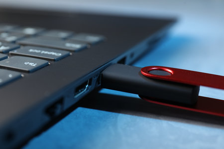 Usb flash drive connected to laptop on blue table, closeupの写真素材