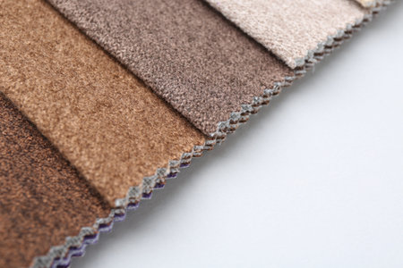 Samples of different fabrics on white background, closeup. Space for text
