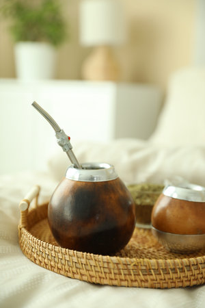 Traditional yerba mate tea on bed indoors, closeup