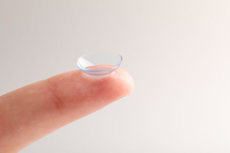 Woman with contact lens on light background, closeup.の写真素材