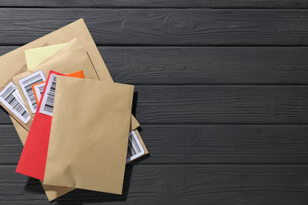 Different paper envelopes on grey wooden table, top view. Space for text