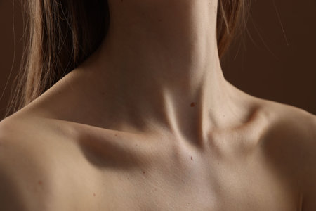 Woman with perfect skin on brown background, closeup