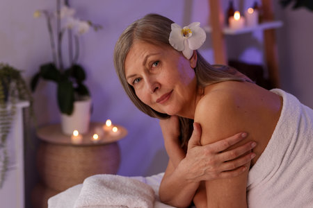 Senior woman relaxing on massage couch in spa salon, space for textの写真素材