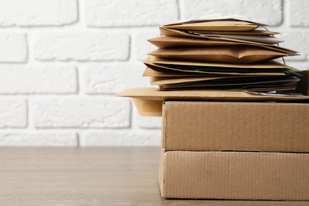 Post office. Different paper envelopes and parcels on wooden table, closeup. Space for textの写真素材