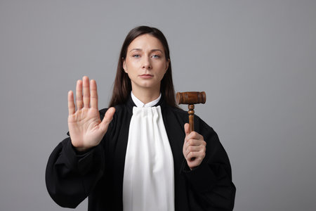 Judge with mallet showing stop gesture on gray backgroundの写真素材
