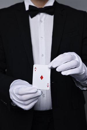 Illusionist with playing card on grey background, closeupの写真素材