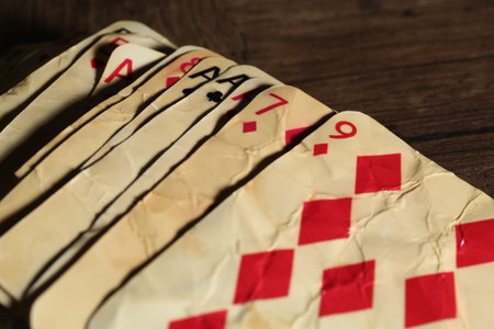 Old vintage playing cards on wooden table, closeup
