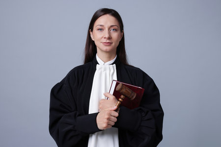 Judge with mallet and book on gray backgroundの写真素材