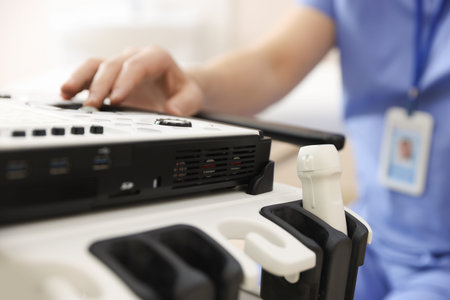 Professional sonographer with ultrasound machine in clinic, closeup