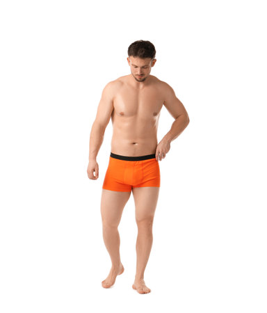 Young man in stylish orange underwear on white backgroundの写真素材