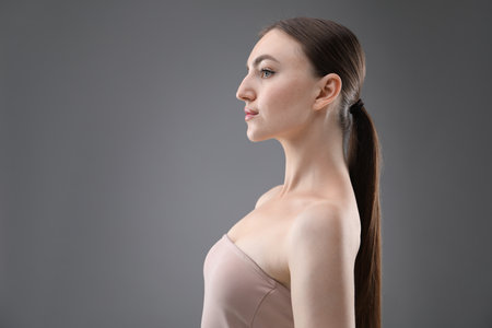 Portrait of beautiful woman on grey background. Space for textの写真素材