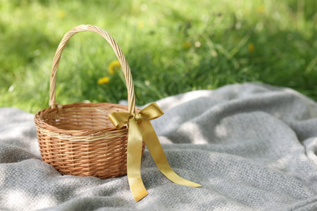 Wicker basket on blanket outdoors. Space for textの写真素材