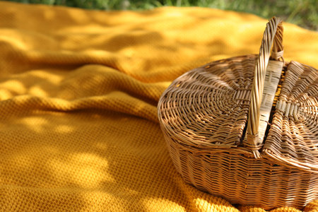 Wicker basket and blanket on green grass outdoors, closeupの写真素材