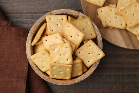 Tasty crackers on wooden table, top view