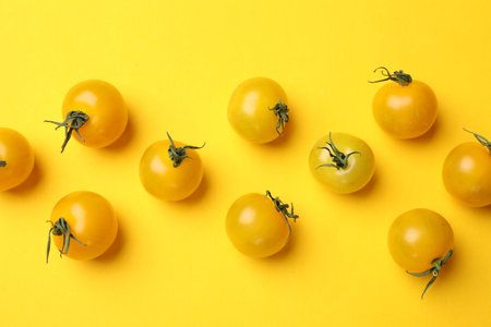 Ripe yellow cherry tomatoes on color background, flat layの写真素材