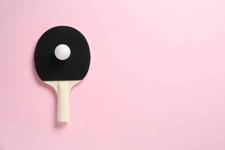 Ping pong racket and ball on pink background, top view. Space for textの写真素材