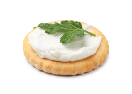 One tasty cracker with cream cheese and parsley isolated on whiteの写真素材