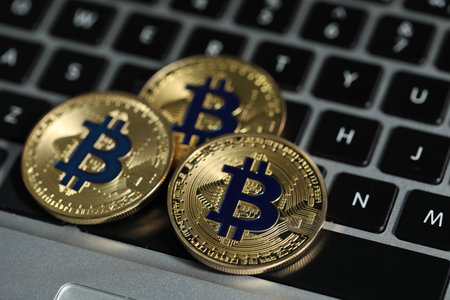 Cryptocurrency. Golden bitcoins on laptop, closeup viewの写真素材