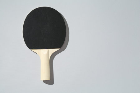 One ping pong racket on light background, top view. Space for text