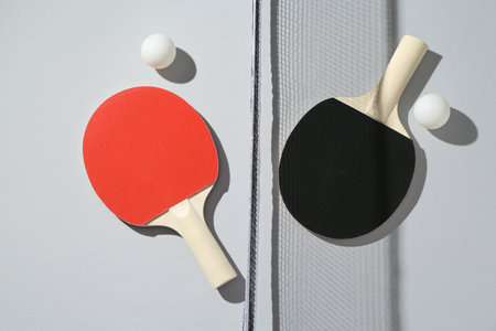 Ping pong rackets, balls and net on light background, flat layの写真素材