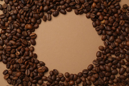 Frame of aromatic coffee beans on beige background, flat lay. Space for textの写真素材