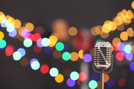 Vintage microphone on dark background with blurred lights, space for text. Musical equipmentの写真素材