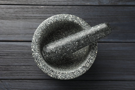 Stone mortar and pestle on black wooden table, top viewの写真素材