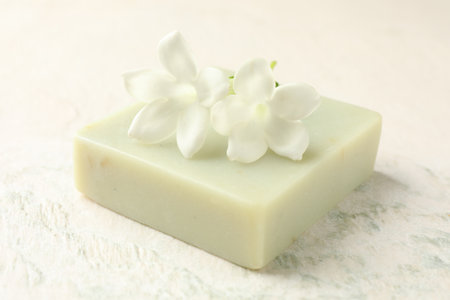 Bar of soap and jasmine flowers on light table, closeupの写真素材