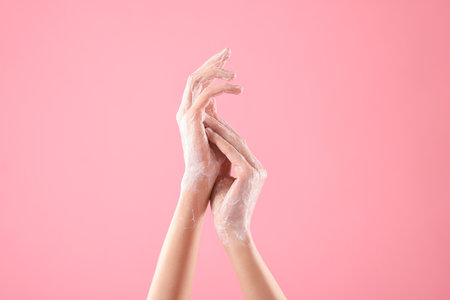 Woman washing hands with soap on light pink background, closeupの写真素材