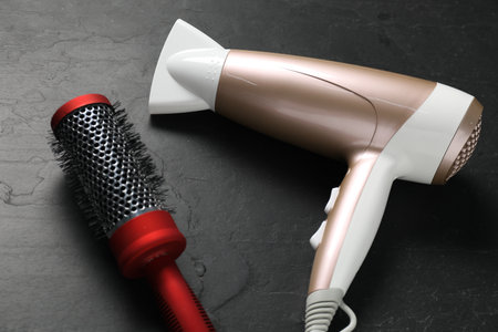 Round brush and dryer on black table, above viewの写真素材