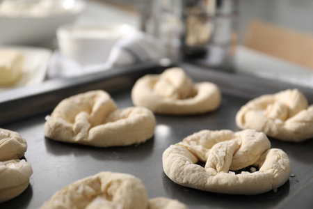 Uncooked pretzels and ingredients on baking dish indoors, closeupの写真素材