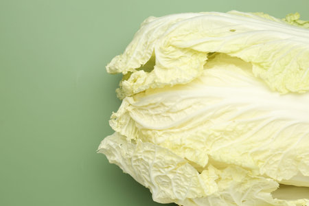 Fresh cabbage on green background, top view. Space for text