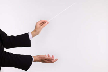 Conductor with baton on light grey background, closeup. Space for textの写真素材