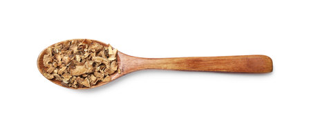Pieces of dry chicory roots in spoon isolated on white, top view