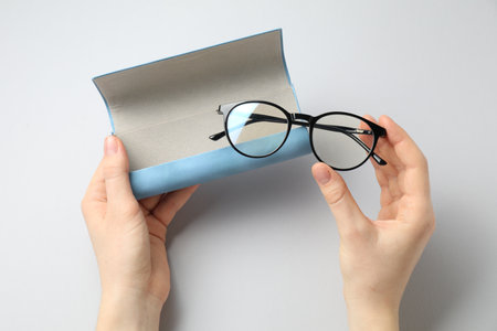 Woman with glasses and case on light background, top viewの写真素材