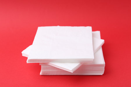Stack of white handkerchiefs on red background, closeupの写真素材