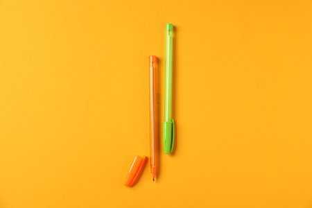 Stylish pens on orange background, flat layの写真素材