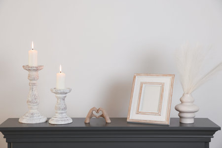 Stylish candlesticks with burning candles and other decor indoors