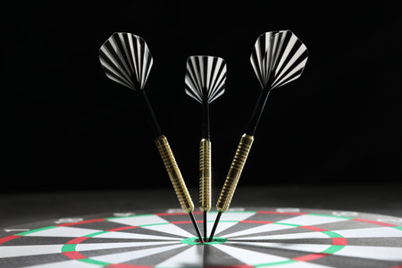 Targeting. Dart board with arrows against dark background, closeup