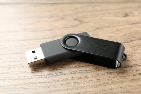 One flash drive on wooden background, closeup