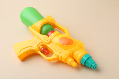 Bright plastic water gun on beige background, closeupの写真素材
