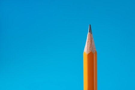 Sharp graphite pencil on light blue background, closeup. Space for textの写真素材