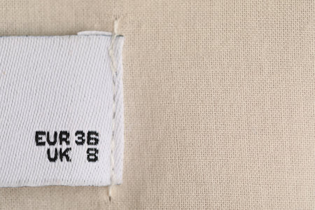 Clothing label on white garment as background, closeupの写真素材