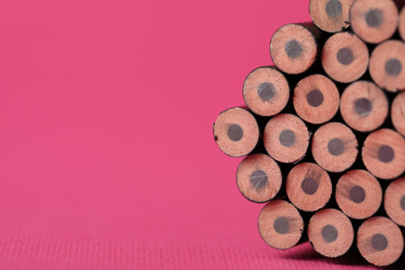 Many sharp graphite pencil on pink background, closeup. Space for textの写真素材