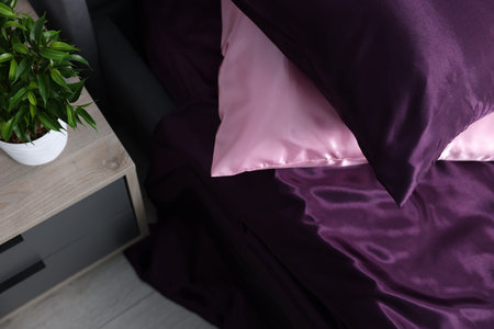 Luxury silk linens on bed and nightstand at homeの写真素材